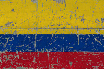 Grunge Colombia flag on old scratched wooden surface. National vintage background.