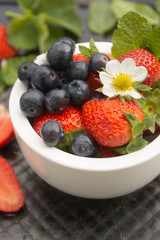 Berries mix in a bowl. Fresh summer strawberries and blueberries with mint leaves. Fruits for smoothie. Healthy food.