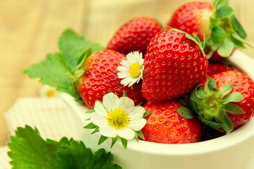 Strawberries in a bowl. Summer fresh berries. Isolated strawberries on wooden table.