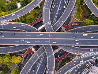 Aerial view of highway junctions shape letter x cross. Bridges, roads, or streets with trees in transportation concept. Structure shapes of architecture in urban city, Shanghai Downtown, China.
