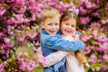 Love is in the air. Kids in love pink cherry blossom. Romantic babies. Couple kids walk sakura tree garden. Tender love feelings. Little girl and boy. Romantic date. Spring time to fall in love