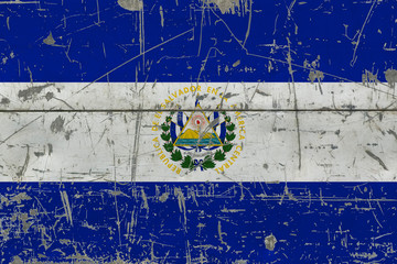 Grunge El Salvador flag on old scratched wooden surface. National vintage background.