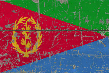 Grunge Eritrea flag on old scratched wooden surface. National vintage background.