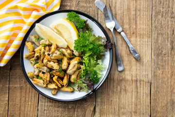 Peeled mussels with fresh lemom. Healthy seafood, natural sunlight, wooden rustic table.