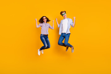 Fototapeta na wymiar Close up full length body size photo of pair in summer specs he him his she her lady boy jumping high in greatness funny go travelling wearing casual plaid shirt outfit isolated on yellow background