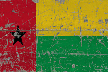 Grunge Guinea Bissau flag on old scratched wooden surface. National vintage background.