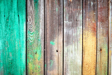 background of old wooden boards with nails, green and yellow paint stains on textured wood plank.
