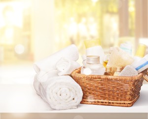 Fototapeta na wymiar Bath towel and basket with accessories for spa on blur background