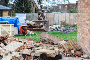 Demolition of the garage in the garden, excavator, selective focus