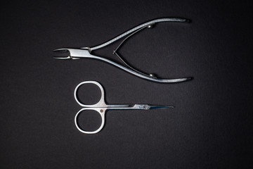 Manicure set of tools made of steel isolated on black background.