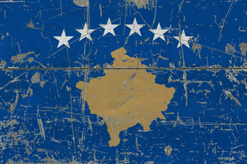 Grunge Kosovo flag on old scratched wooden surface. National vintage background.