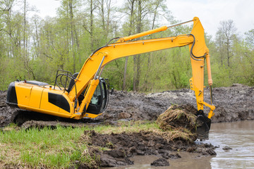 Excavator picks up big amount of soil for construction irrigation system canal in countryside for...