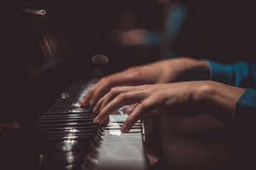 one male hand on the piano. The palm lies on the keys and plays the keyboard instrument in the...