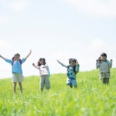 草原ではしゃぐ小学生