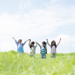 草原で手をつなぐ小学生