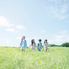 草原で手をつなぐ小学生