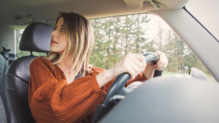 woman sitting on a driver place and hold a steering wheel