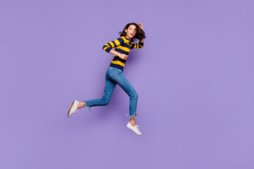 Fototapeta na wymiar Full length side profile body size photo beautiful she her lady jump high flight hurry shopping sale discount mall store motion wear blue yellow striped pullover isolated violet purple background