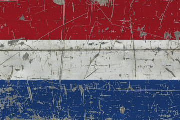 Grunge Netherlands flag on old scratched wooden surface. National vintage background.