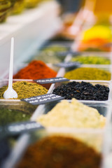 Spices and condiments in boxes on the counter of the vegetable market. 