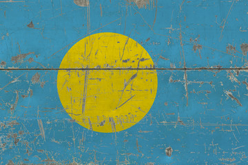 Grunge Palau flag on old scratched wooden surface. National vintage background.