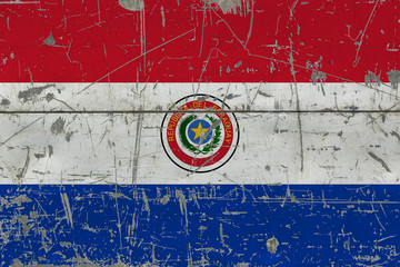 Grunge Paraguay flag on old scratched wooden surface. National vintage background.