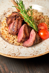 Knuckle meat dish with a side dish on a blue plate. Dark wooden background.