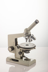 White microscope on table over white background close up