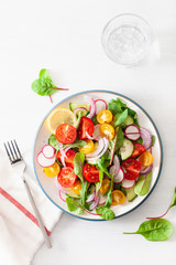 healthy colorful vegan tomato salad with cucumber, radish, onion