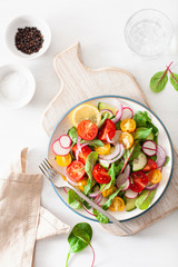 healthy colorful vegan tomato salad with cucumber, radish, onion