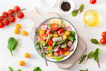 healthy colorful vegan tomato salad with cucumber, radish, onion
