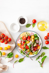 healthy colorful vegan tomato salad with cucumber, radish, onion