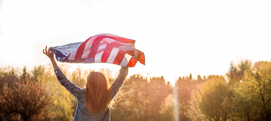 Happy women patriot running in the field with American flag. USA celebrate 4th of July