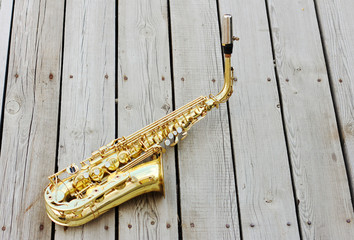  Saxophone on a wooden background. Golden saxophone