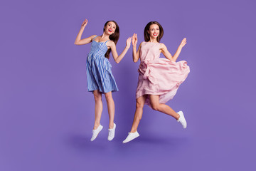 Naklejka premium Full length body size photo two people beautiful funky she her models chic ladies jumping high best cheerleaders fans celebrating breakthrough wear summer dresses isolated purple violet background