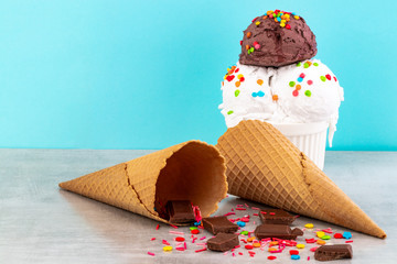 plate of vanilla and chocolate ice cream scoops swith sprinkles chocolate pieces and waffle cones...