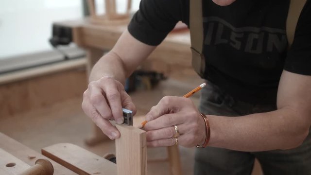 Woodworker accurately measures and scribes end of lumber.