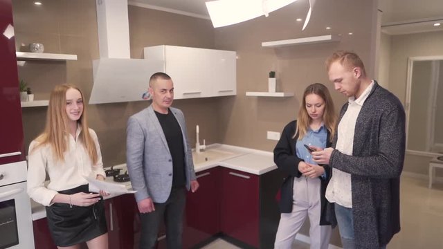 Caucasian Realtors Real Estate Brokers Showing Kitchen in New Property To Potential Buyers Couple. Light Camera Movement