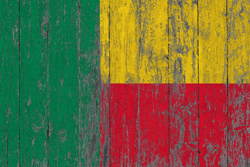 Flag of Benin painted on worn out wooden texture background.