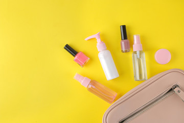 Stylish fashionable pink bag and women's cosmetics and accessories on a bright trendy yellow background. female accessory concept. top view