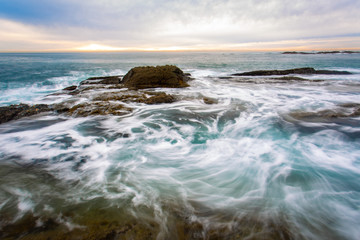 Southern California beach landscape of ocean waves hitting rocks long exposure