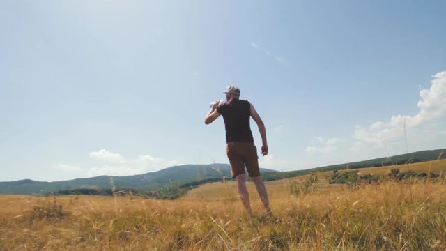 Mountaineer drinks water from a plastic 2l bottle.