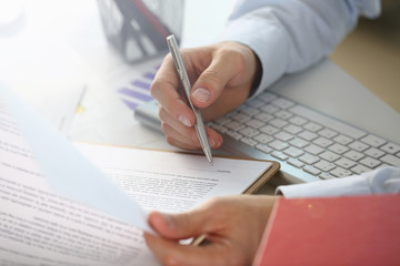 Hand of businessman in suit filling and signing with silver pen partnership agreement form clipped to pad closeup. Management training course some important document team leader ambition concept