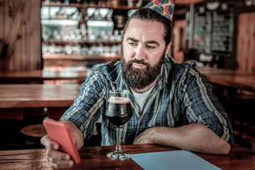 Glooming black-bearded man going to make a call.