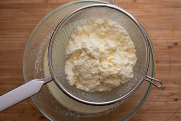 Freshly made ricotta cheese in a sieve