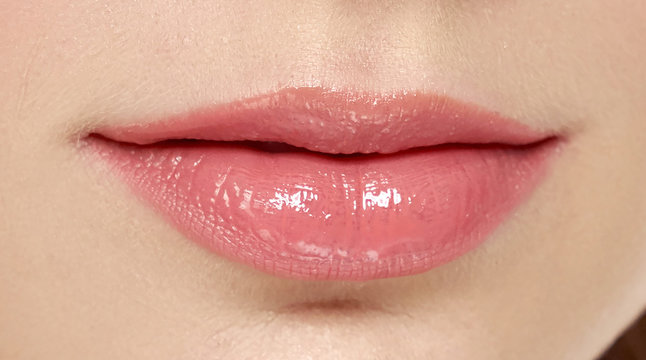Sensual female pink plump lips close up. 
