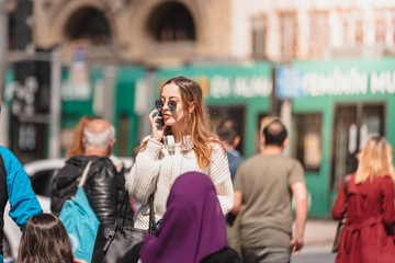 Beautiful woman uses smartphone while walking