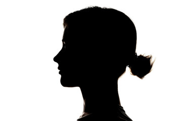 Obraz na płótnie Canvas Dark silhouette profile of a young girl on white background, concept of anonymity