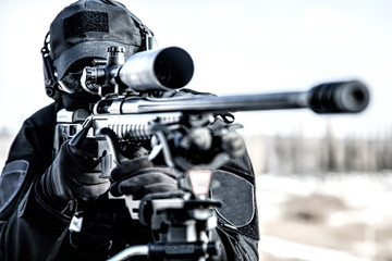 Equipped police SWAT sniper shooting with rifle