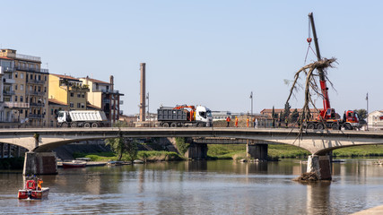 PISA, TUSCANY/ITALY  - APRIL 18 : Workmen lifting a dead tree from the Arno river at PisaTuscany Italy on April 18, 2019. Unidentified people
